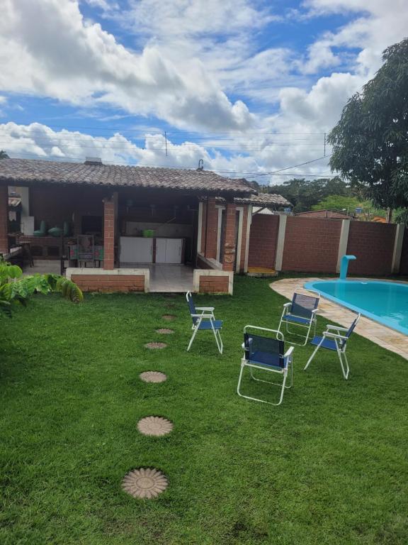 a yard with chairs and a swimming pool at Flat Alto Padrão in Gravatá