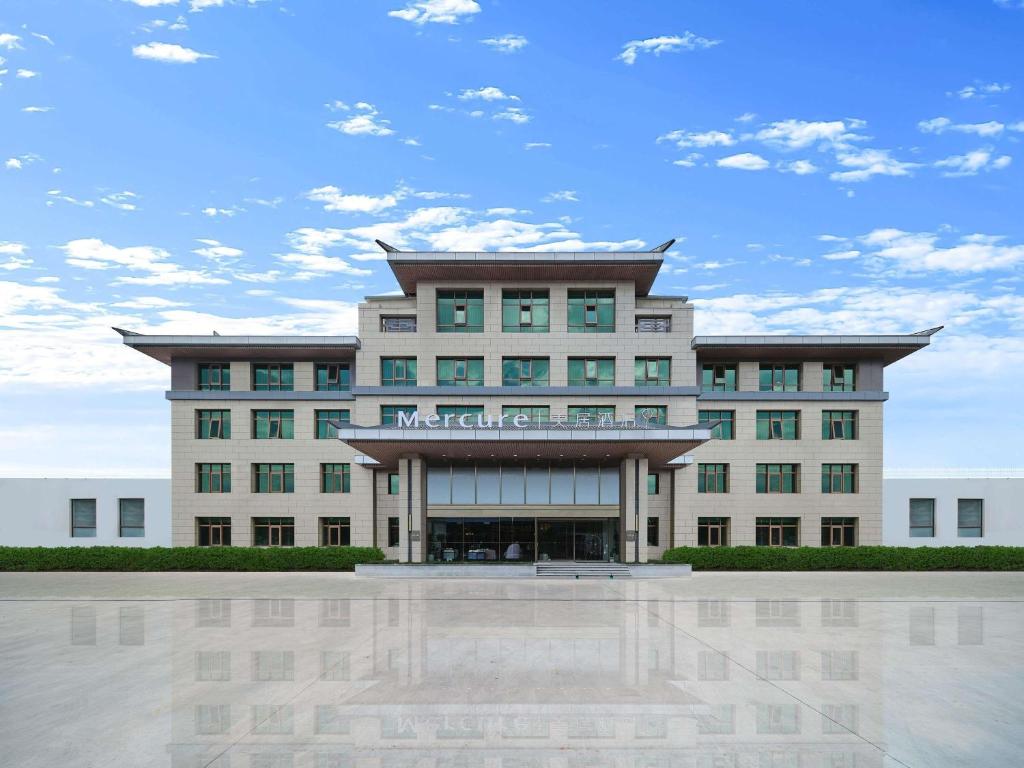 a large building with a reflecting pool in front of it at Mercure Beijing Universal Resort in Beijing