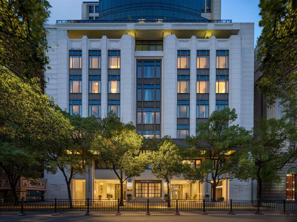 a large white building with trees in front of it at Mövenpick by Accor Shanghai People's Square in Shanghai