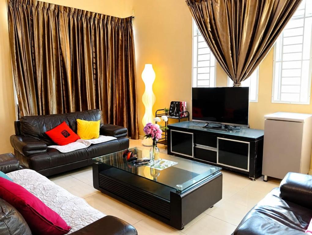 a living room with a couch and a tv at Family Retreat w Kid Pool, BBQ Games Sleeps 10pax Melaka in Kampong Beringin