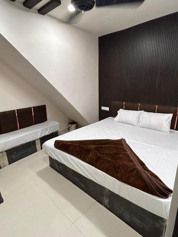 a bedroom with a large bed and a black wall at Hotel Maa Parwati in Ujjain