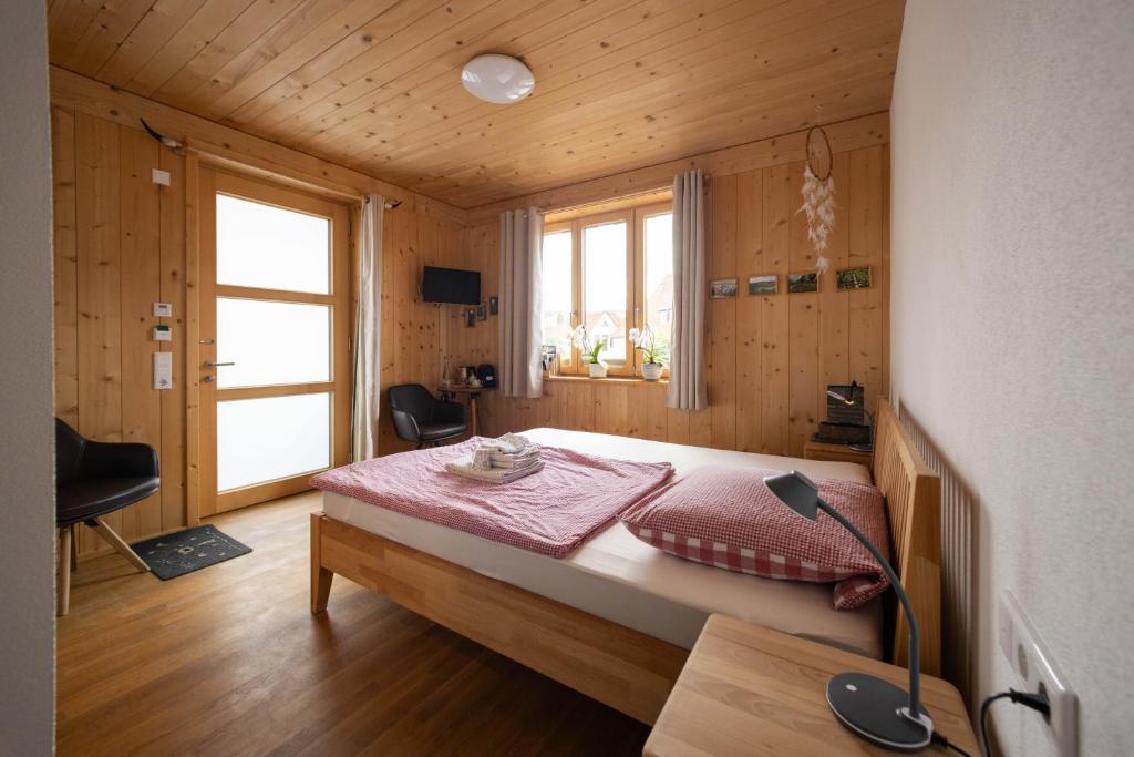 a bedroom with a bed in a wooden room at Übernachtung beim Bio-Metzger "Zimmer Rosl" in Mössingen