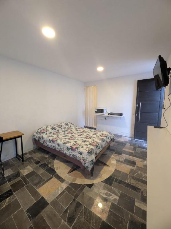 a bedroom with a bed and a table in a room at Nova Suites in San Juan Xilotzingo