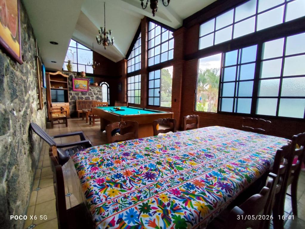 a dining room with a table with a colorful table cloth at Quinta Huicochea in Cuernavaca