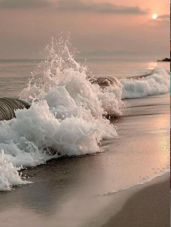 a wave breaking on the beach at sunset at Stay at arugambay in Pottuvil