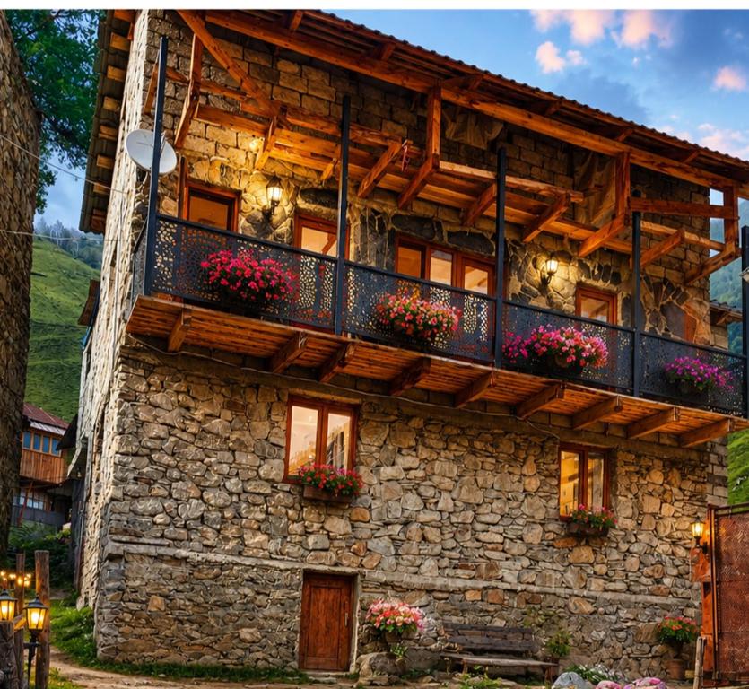 a stone building with flower boxes on it at Stone House marexi in Adishi