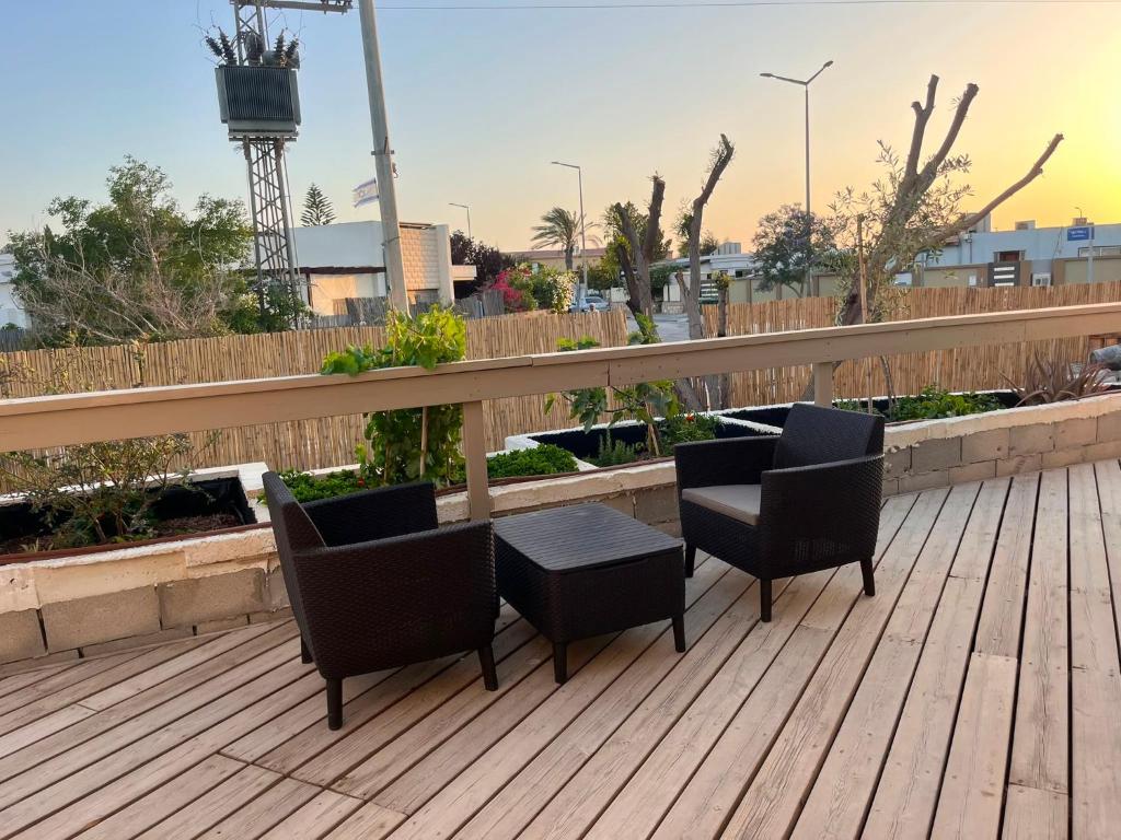a patio with two chairs and a table on a deck at בית בערבה in Mitzpe Ramon