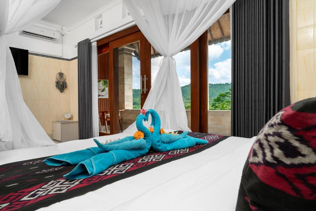 a bedroom with a bed with blue towels on it at Aby Guest House in Sidemen