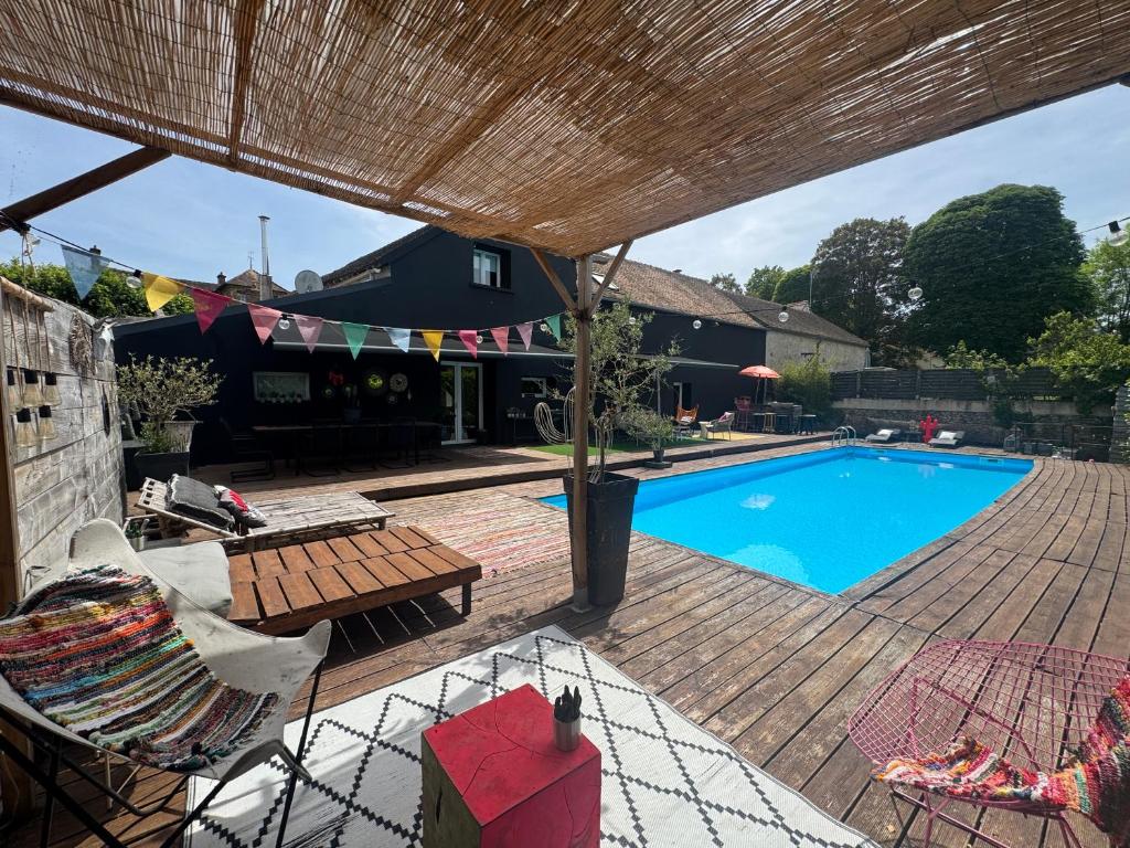 a patio with a swimming pool and a wooden deck at La Villa d'ElodibiZa, 45mn de Paris en train avec piscine ! in Écuelles