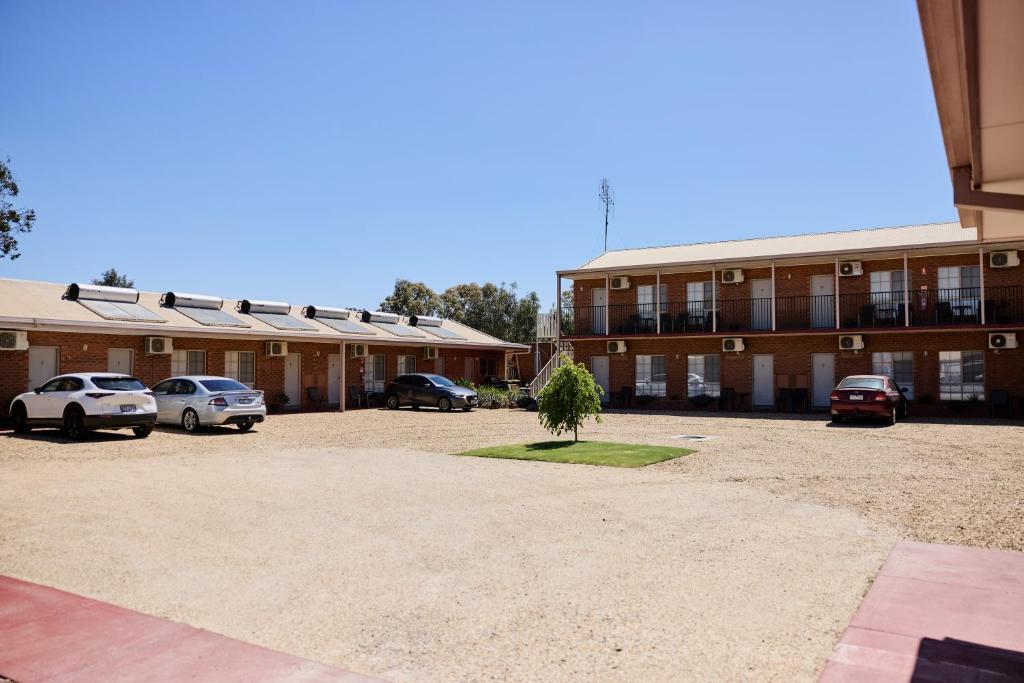a parking lot in front of a building with cars parked at Bridge Motor Inn Tocumwal in Tocumwal