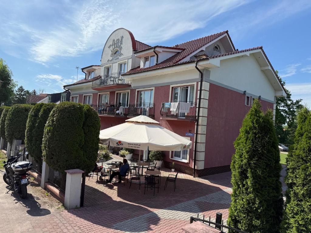 a building with an umbrella and tables and chairs at Tedi 2 in Rewal