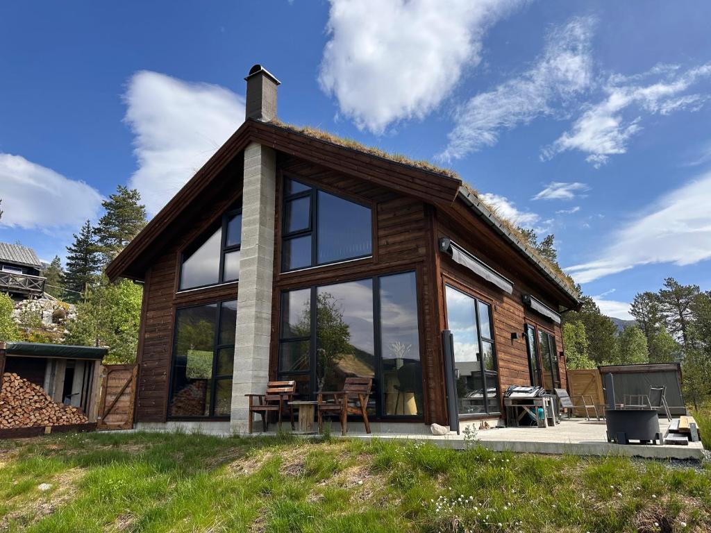 a cabin with large glass windows and a stove at Stryn Nature Lodge in Stryn