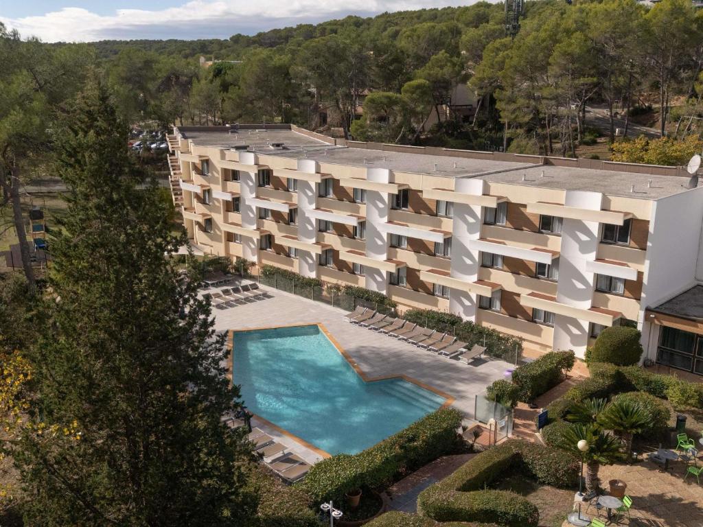 an aerial view of a building with a swimming pool at Novotel Antibes Sophia Antipolis in Valbonne