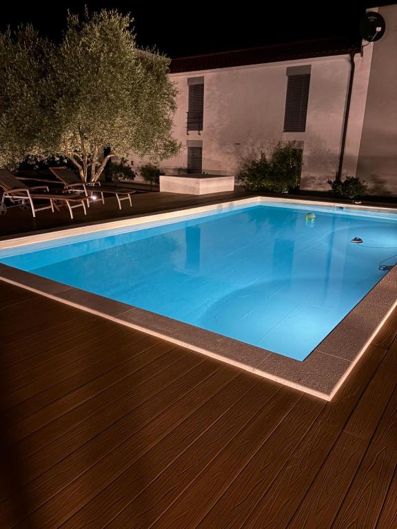 a swimming pool in a backyard at night at Beach House Mostir in Ugljan
