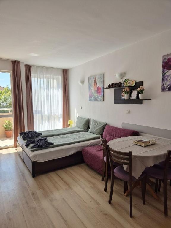 a bedroom with a bed and a table and a couch at Studio Kasandra in Hisarya