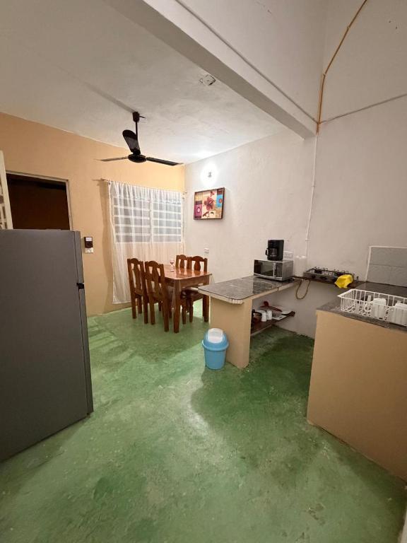 a living room with green floors and a table and chairs at Pakal 2 Apartment in Palenque