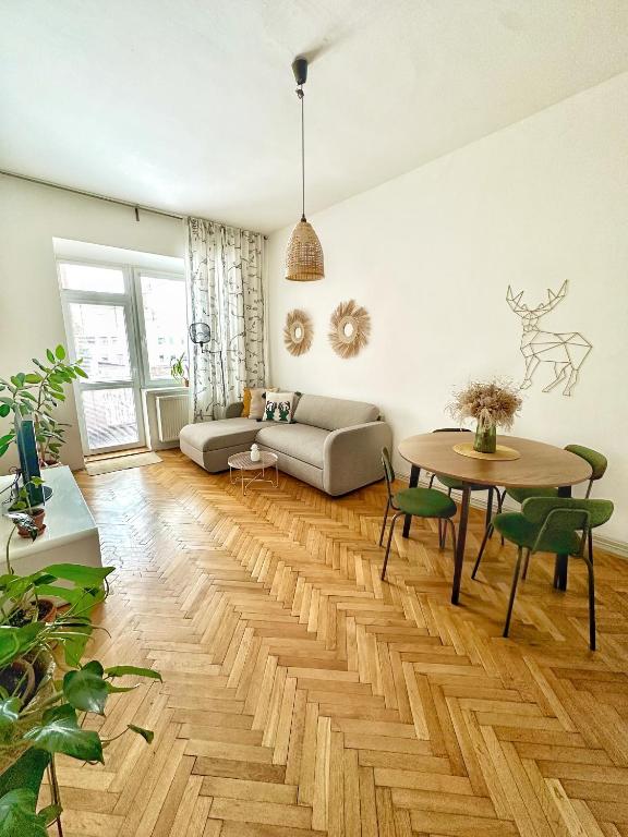 a living room with a table and a couch at Bright and central suite with a balcony in Brno