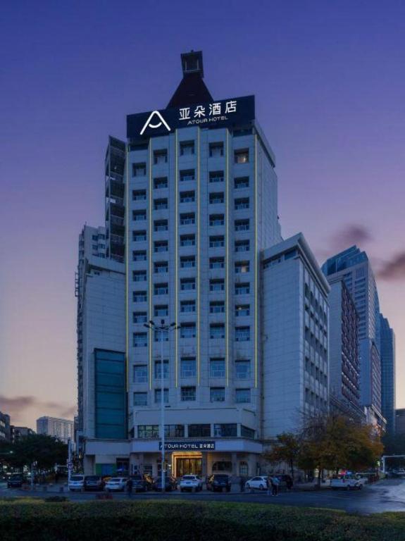 a tall building with a sign on top of it at Atour Hotel (Urumqi Renmin Cinema) in Ürümqi