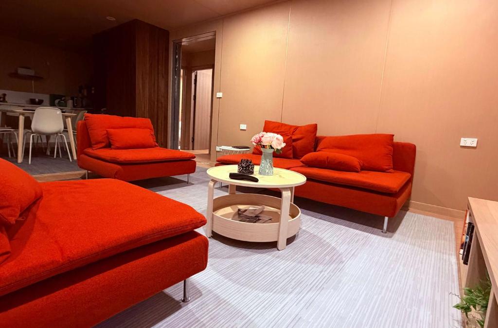a living room with red couches and a table at Cabin 6- Snowy Accommodation in Adaminaby