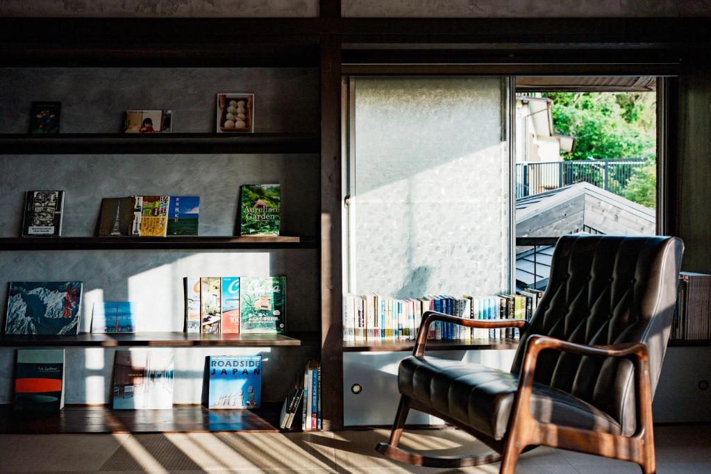 a living room with a chair and a window at 海と富士山を望む4名1棟貸し古民家宿 最大7名 鎌倉エリアの隠れ家 in Zushi