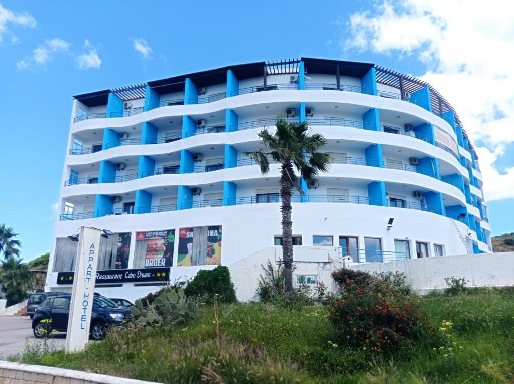 a building with a palm tree in front of it at Appart hôtel Cabo dream in Cabo Negro