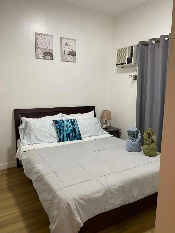 a bedroom with a bed with white sheets at Antara Residences - 1BR in Talisay