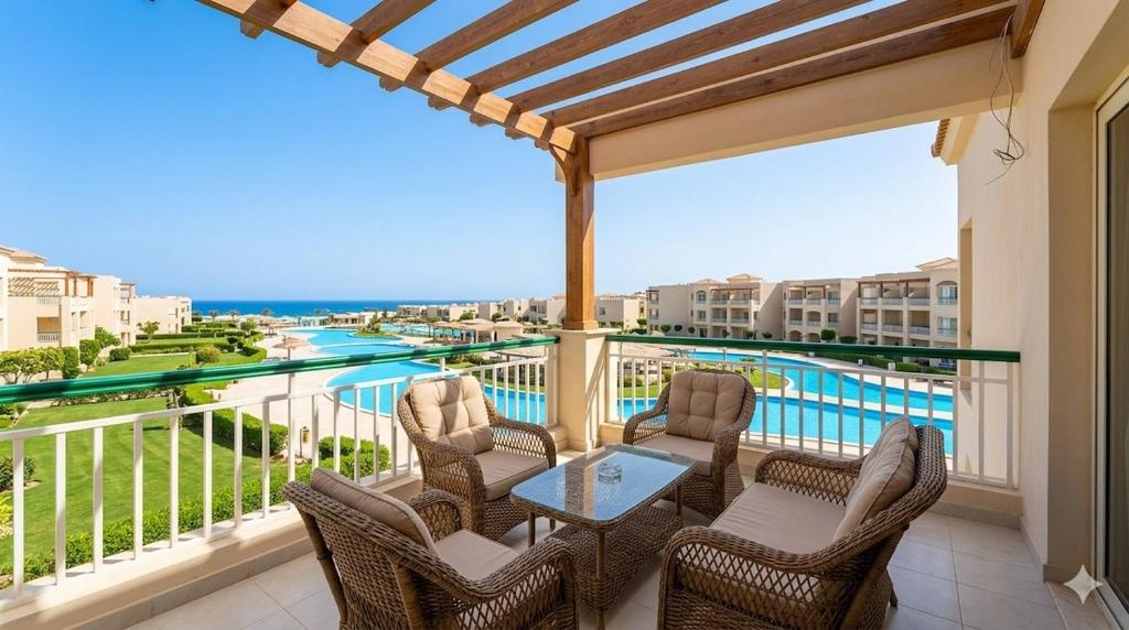 a balcony with a table and chairs and a pool at Laserina North Coast in Zāwiyat ‘Abd al Mun‘im