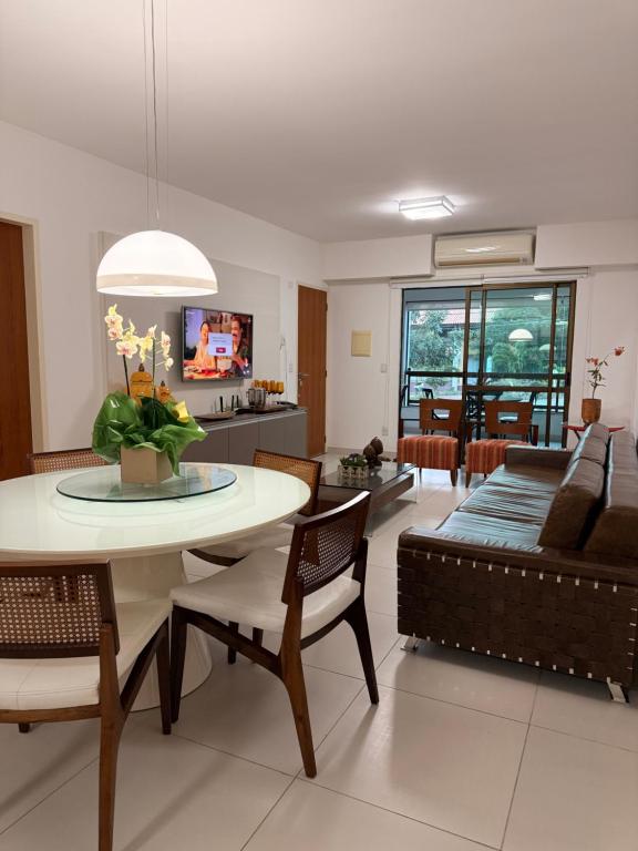 a living room with a table and a couch at Flat Hotel Canarius Gravatá in Gravatá