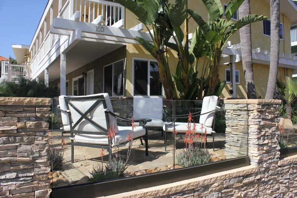 two chairs and a table in front of a house at The Beach Palms Carlsbad in Carlsbad