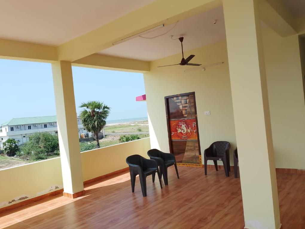 a room with chairs and a balcony with a view at Sagara Darshanam in Vetāpālem