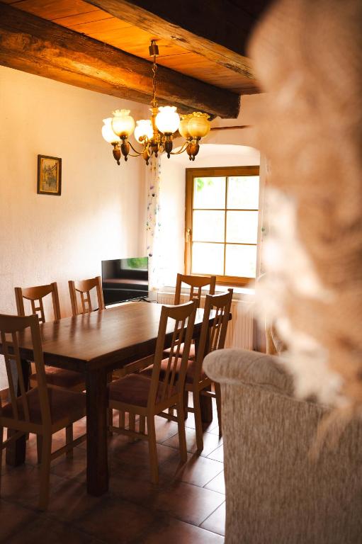 a dining room with a wooden table and chairs at Statek VRANČ - U Kačenky in Bítov