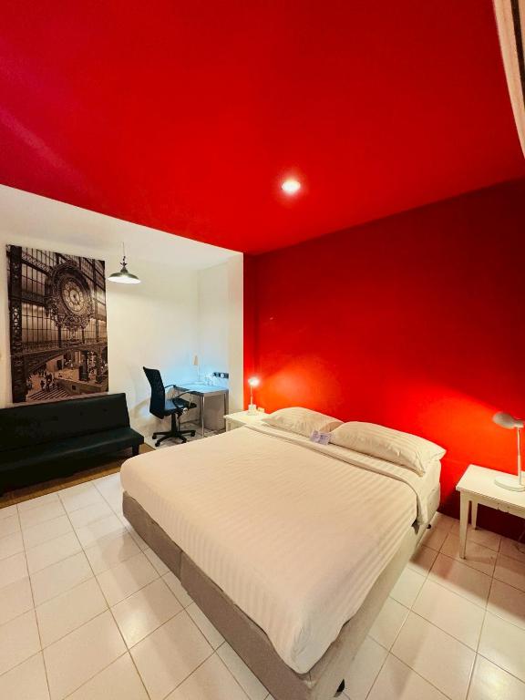 a red bedroom with a bed and a desk at Sino @ Thungsong in Thung Song