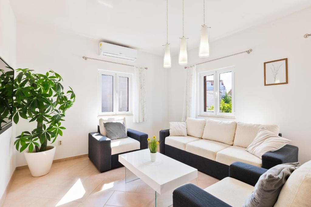 a living room with a couch and a table at APARTMENT MARCELA SUTIVAN - large two-bedroom apartment with two bathrooms - excellent location right by the town center and the beach - parking space provided - panoramic view of the sea and the town in Sutivan