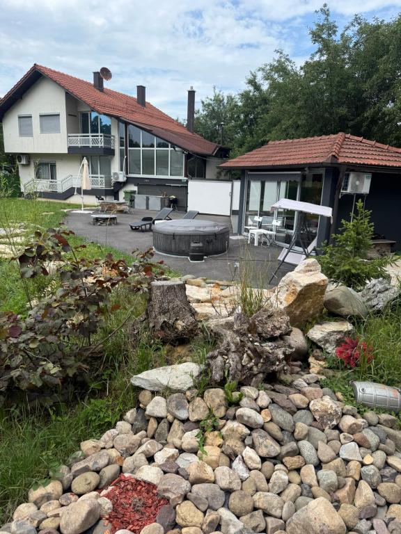 a backyard with a rock garden in front of a house at Venero - Apartmani in Dubrave Gornje