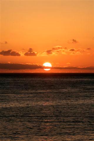a sunset over the ocean with the sun setting at Hotel Gran Rey in Valle Gran Rey
