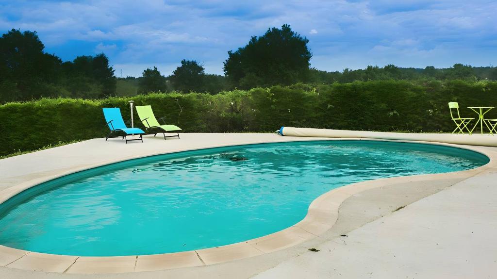 a swimming pool with two lawn chairs and two chairs at Les Chambres D'Anel in Saint-Pourçain-sur-Besbre