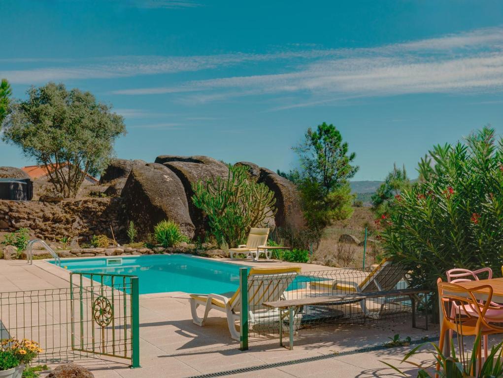 a pool in a patio with chairs and a table at Quinta da Estrela in Ponte Nova
