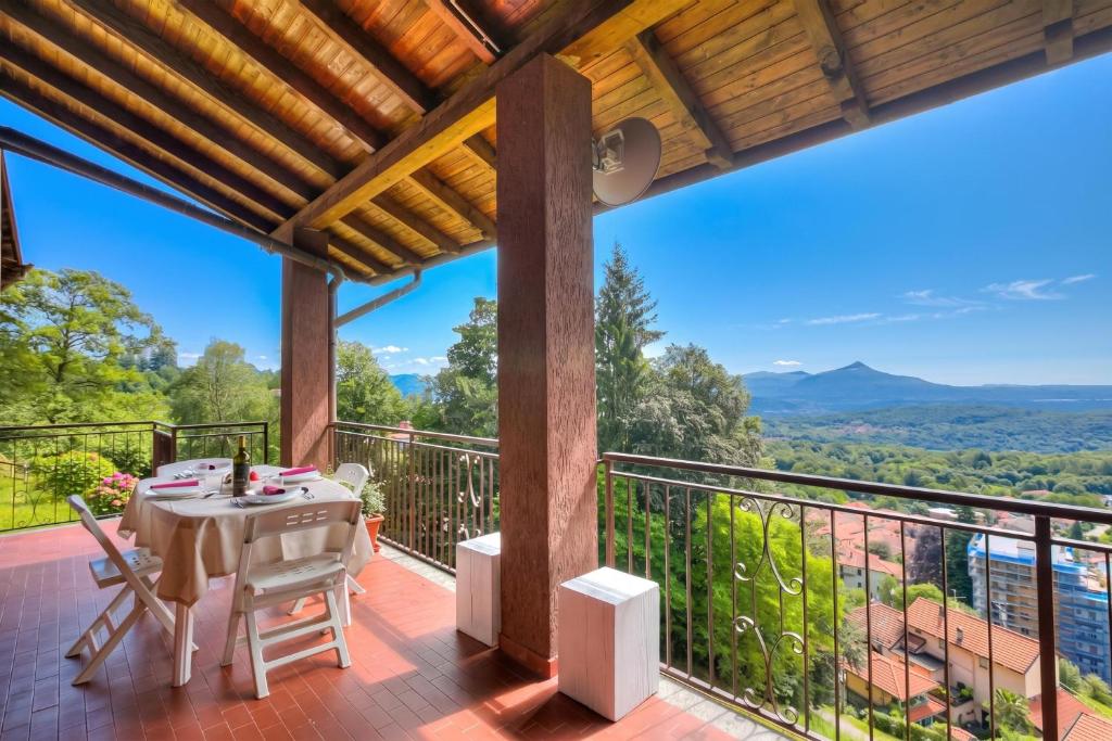 a patio with a table and chairs on a balcony at Il Vecchio Faggio: Lake Maggiore view Terrace - Happy Rentals in Gignese