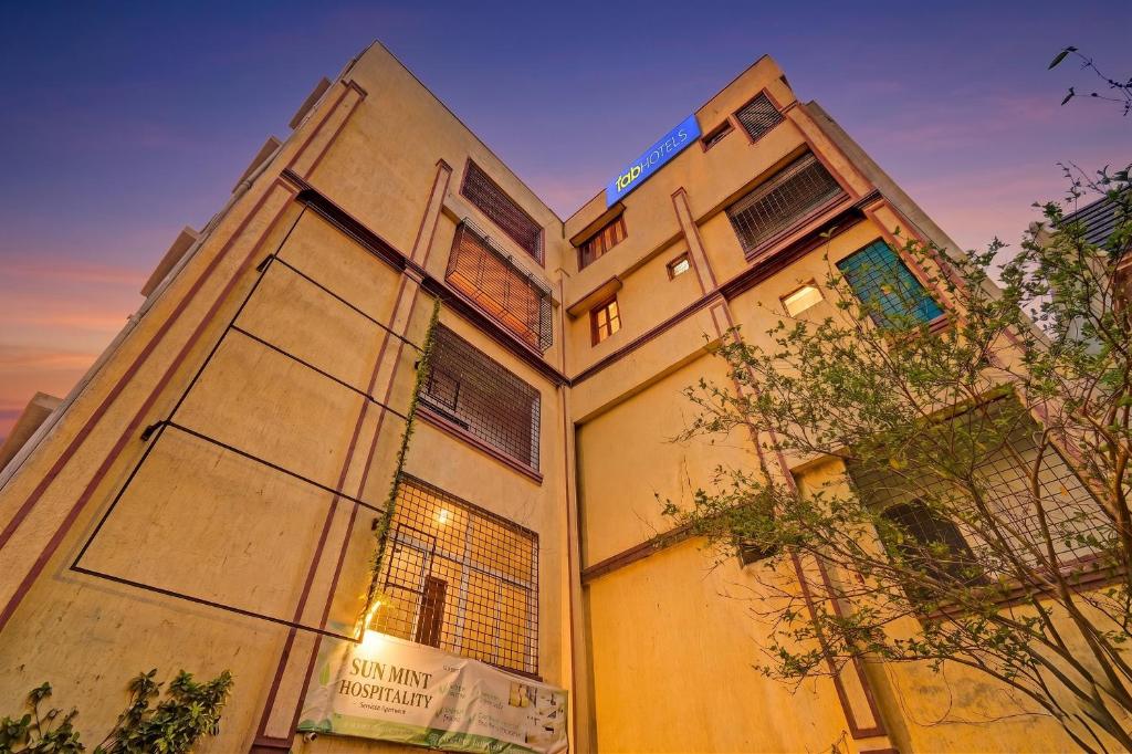 a tall building with windows and a sign on it at FabHotel Sun Mint - Jubilee Hills in Hyderabad