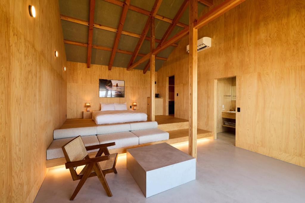 a bedroom with two beds and a table in a room at DEAR MOM - Hotel & Cafe in Onjuku