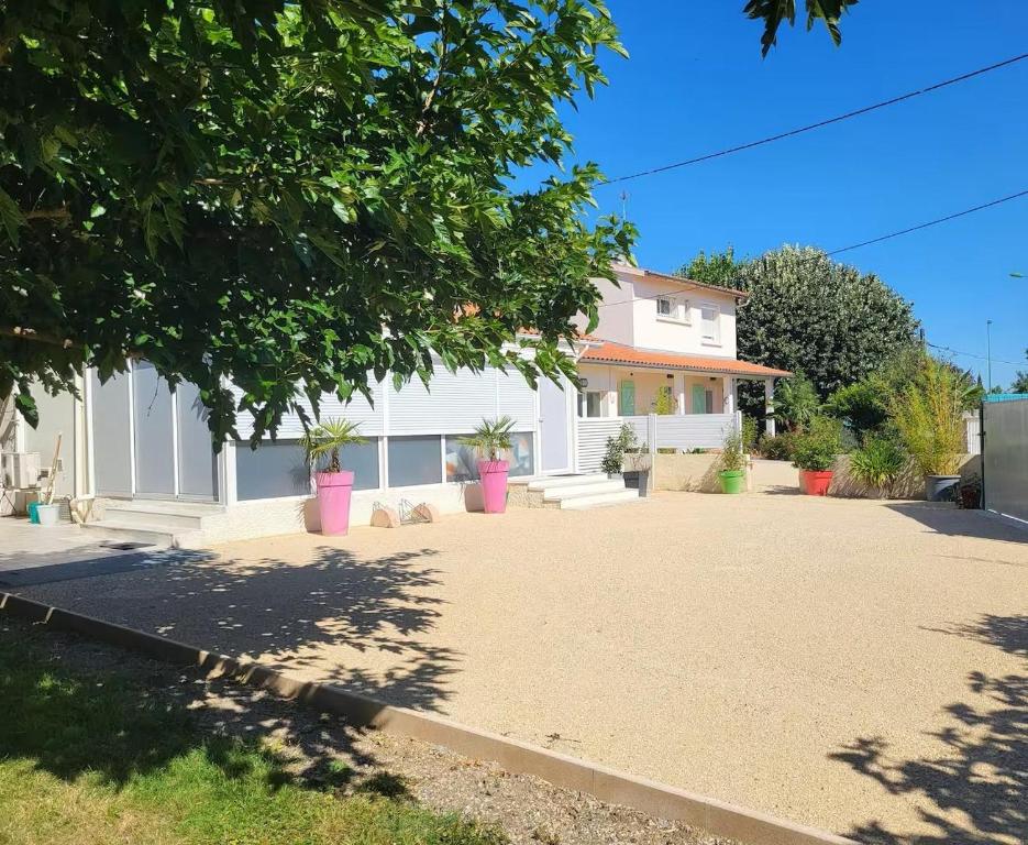a white house with a driveway in front of it at Maison venitia 14 personnes in Aussonne