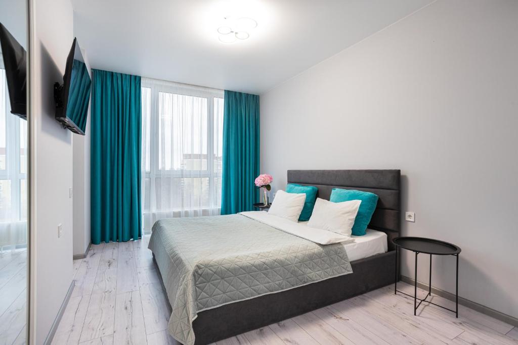 a bedroom with a large bed with blue pillows at Nyvky Like Home - Fayna Town - apt 149 8 поверх, 1 буд in Kyiv
