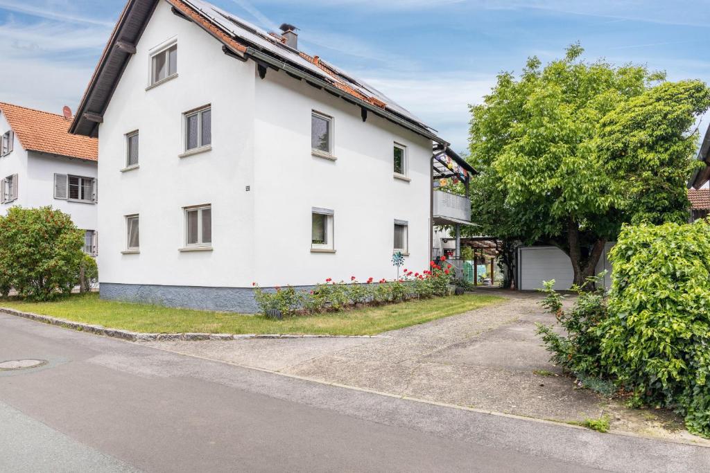 a white house with a tree and a street at A Casa Alfred Kemmern in Kemmern