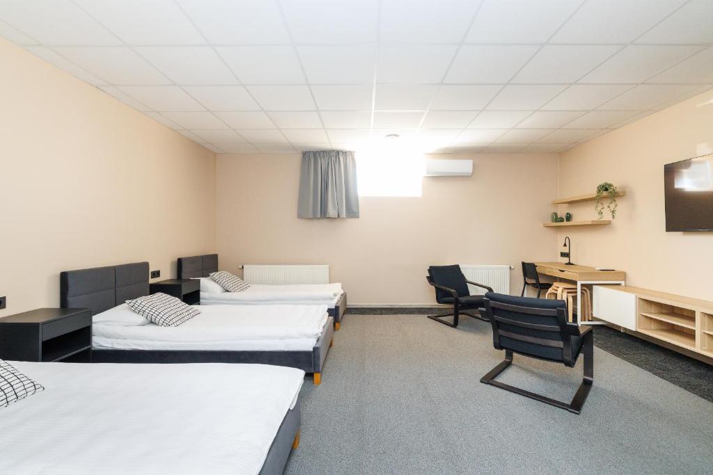 a room with three beds and a desk and a computer at Air Kaunas apartment in Karmėlava
