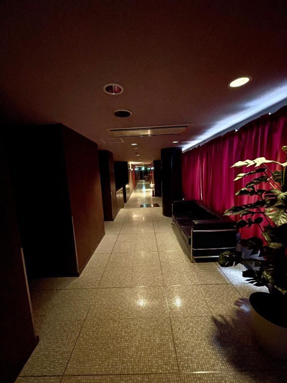 a hallway in a building with a pink curtain at ホテル アクティ エクシブ in Asahi