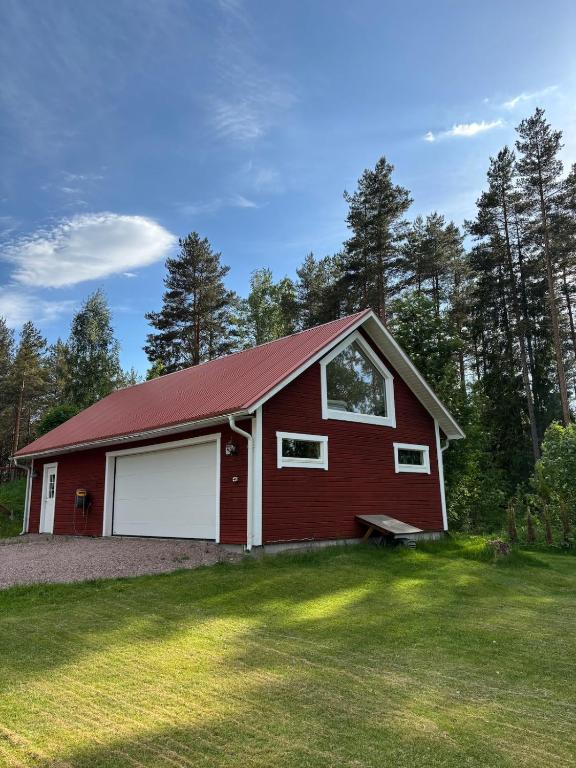 a red barn with a white garage at Halsmo 6 in Kil
