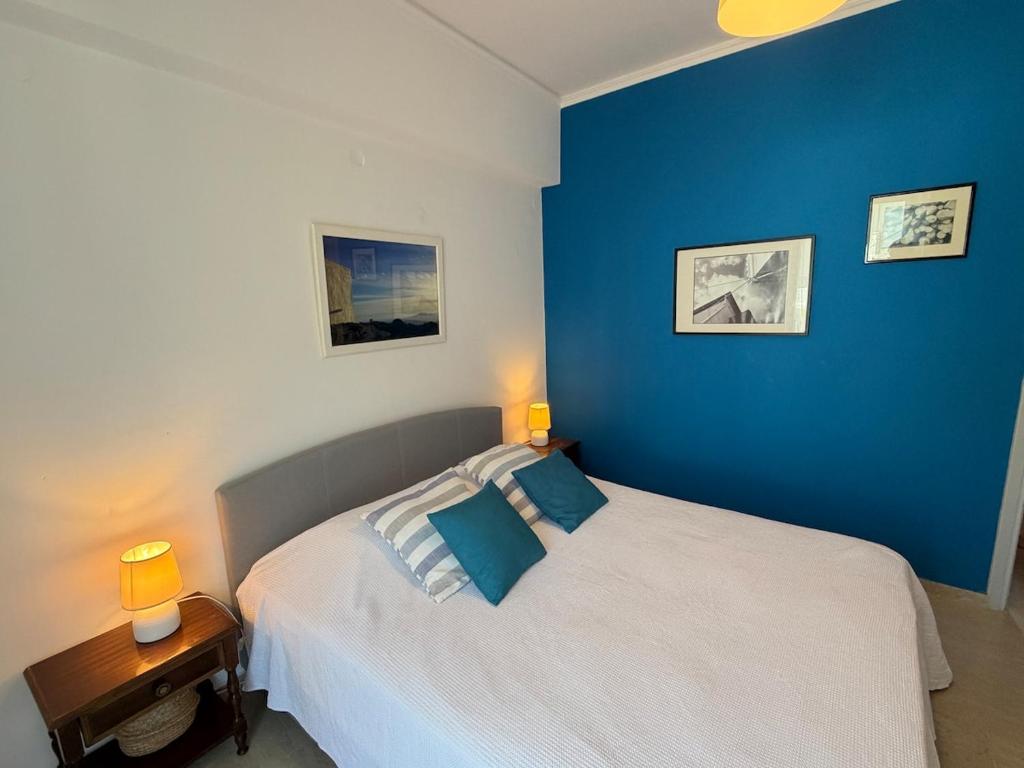 a bedroom with a bed with a blue wall at Art & Motion Union - Guest Room 3 in Apoíkia