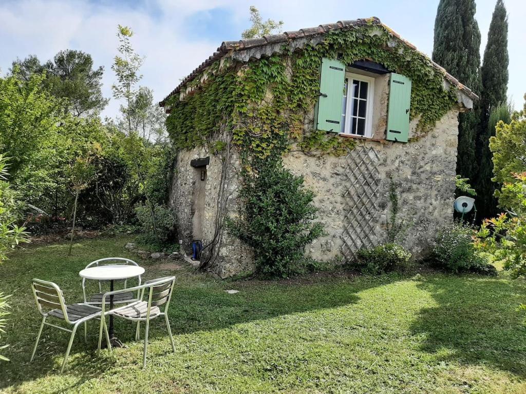 a table and chairs in front of a house at Maisonnette de caractère au calme in Fayence