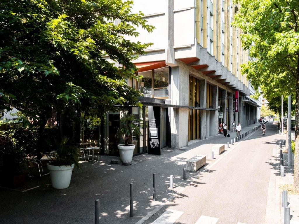 a city street with trees and a building at Mercure Grenoble Centre Alpotel in Grenoble