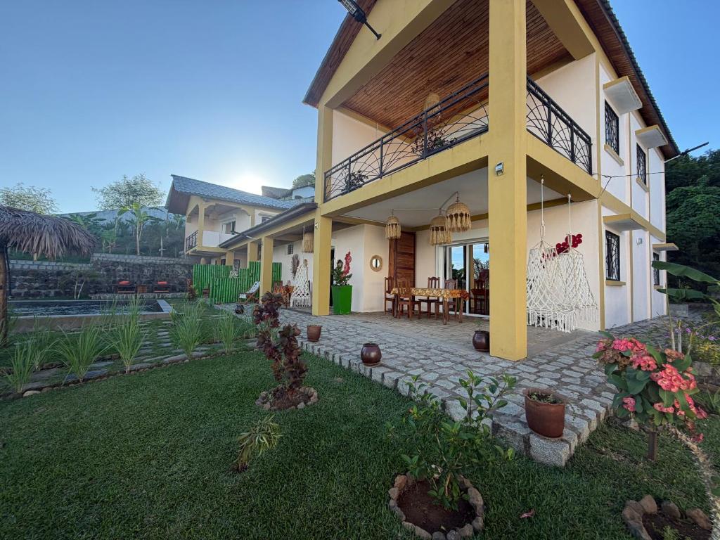 a house with a patio and a yard at Villa Baby lodge in Hell-Ville